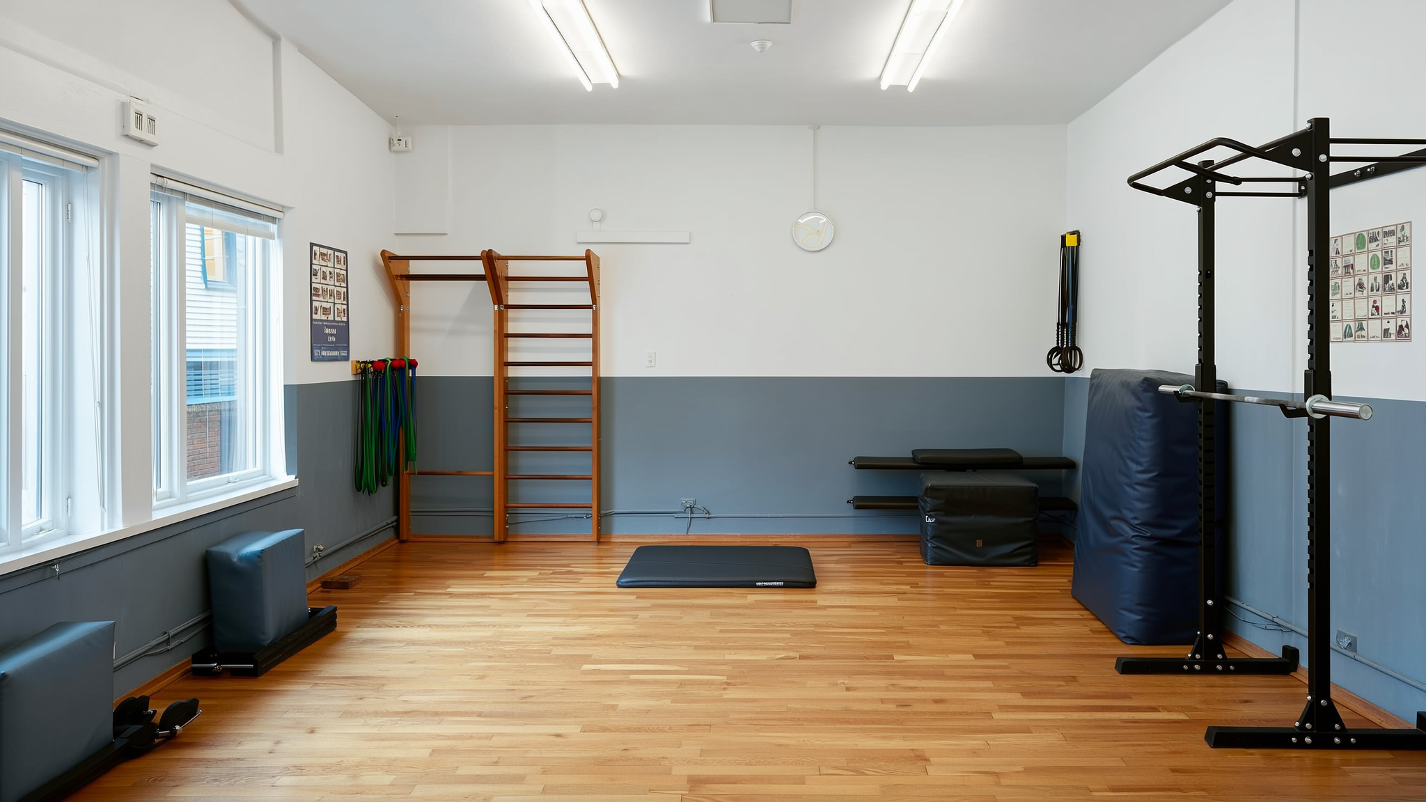 Oefenzaal met wandrek, trainingsmateriaal en matten