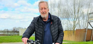 Deelnemer aan de fietsvalpreventietraining op een fiets, buiten in de wijk